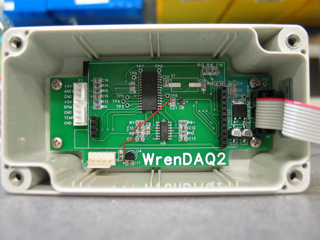 WrenDAQ2 main circuit board. There is a PIC18F2610 microcontroller (U5) in the center of the board. The passive parts on the left are low-pass filters for the anemometer and RPM inputs. The passive parts at the op-amp (U3) are low pass filters for the ...